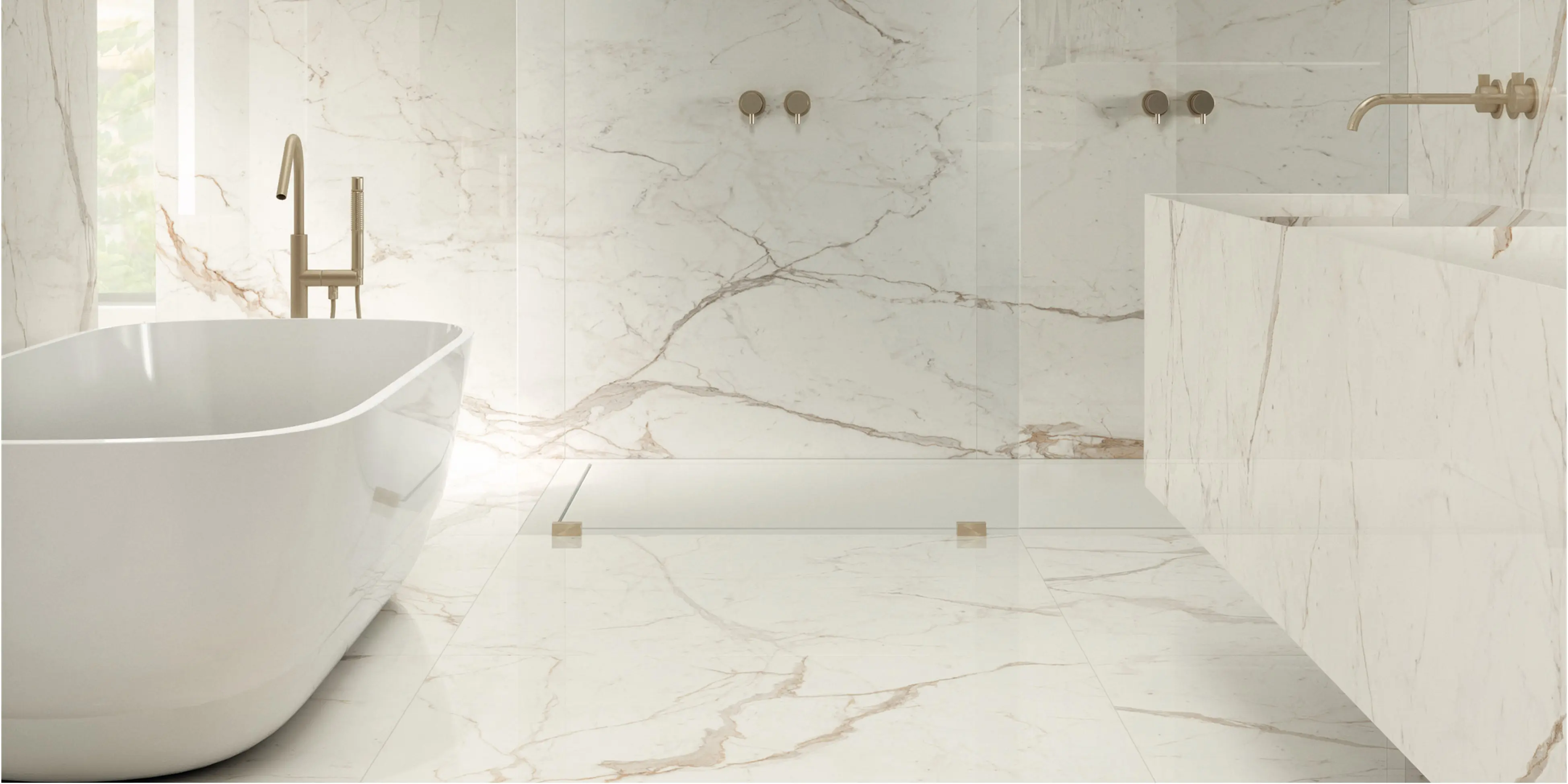 Storformat fliser, med marmorlook i hvidlige farve med beige åre, på vægge og gulv i badeværelset, skaber et roligt look.