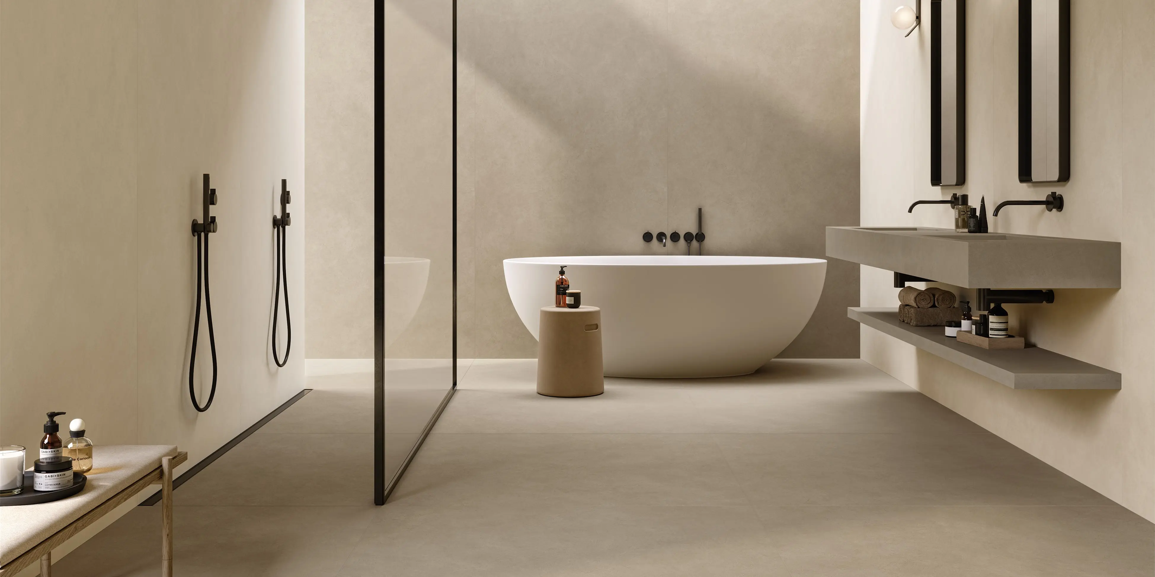 Moderne store fliser i jordlig nuancer som giver enkelt udseende i badet. Kun få vigtige elementer, som vask lavet af de samme fliser, og glasbruseniche er i rummet.