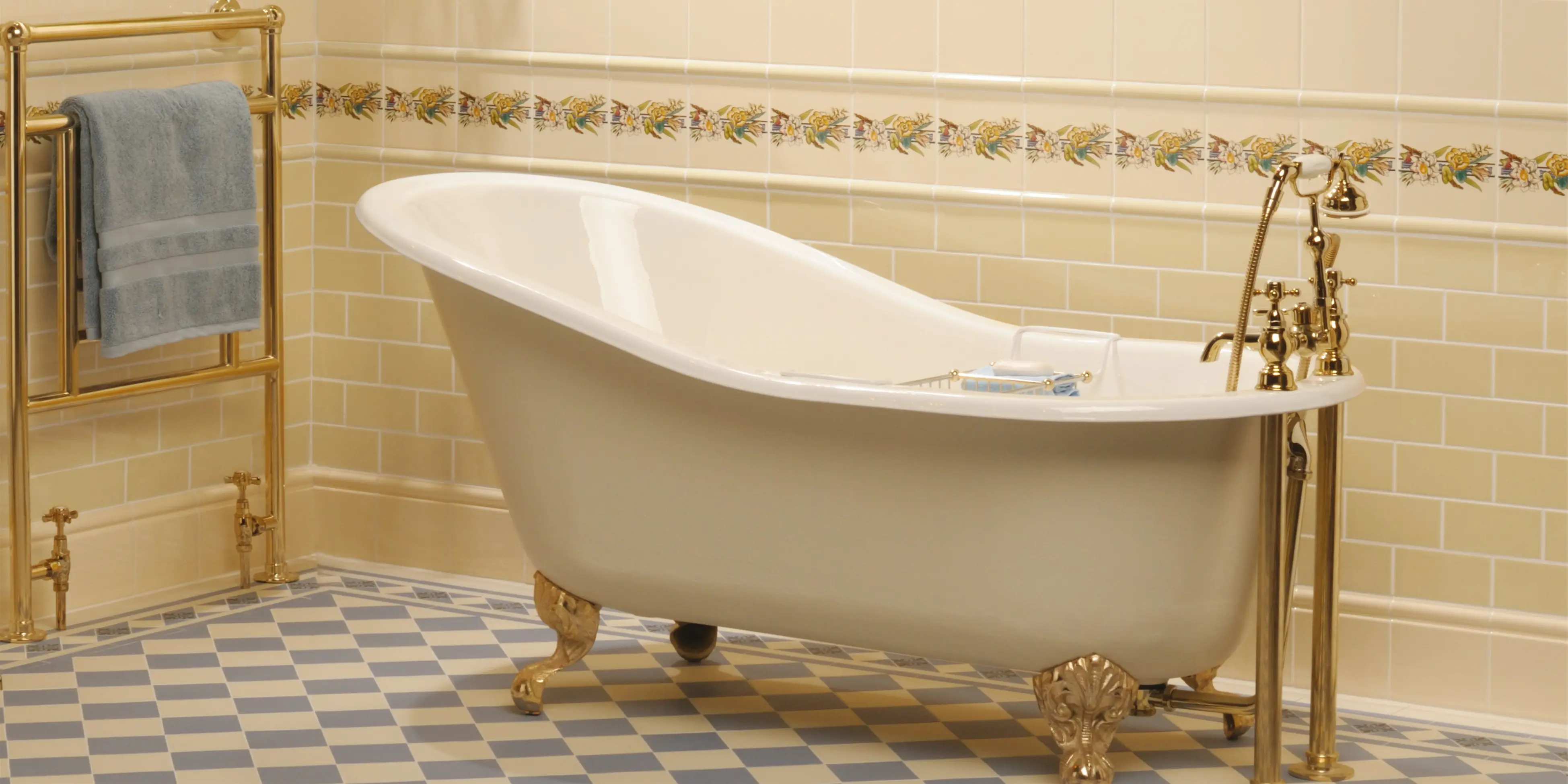 Klassisk badeværelse med 7,5x15cm cream vægfliser. Et smukt badekar på messing løvefødder, stående på et traditionelt skakternsgulv cream og grå i 15x15cm.